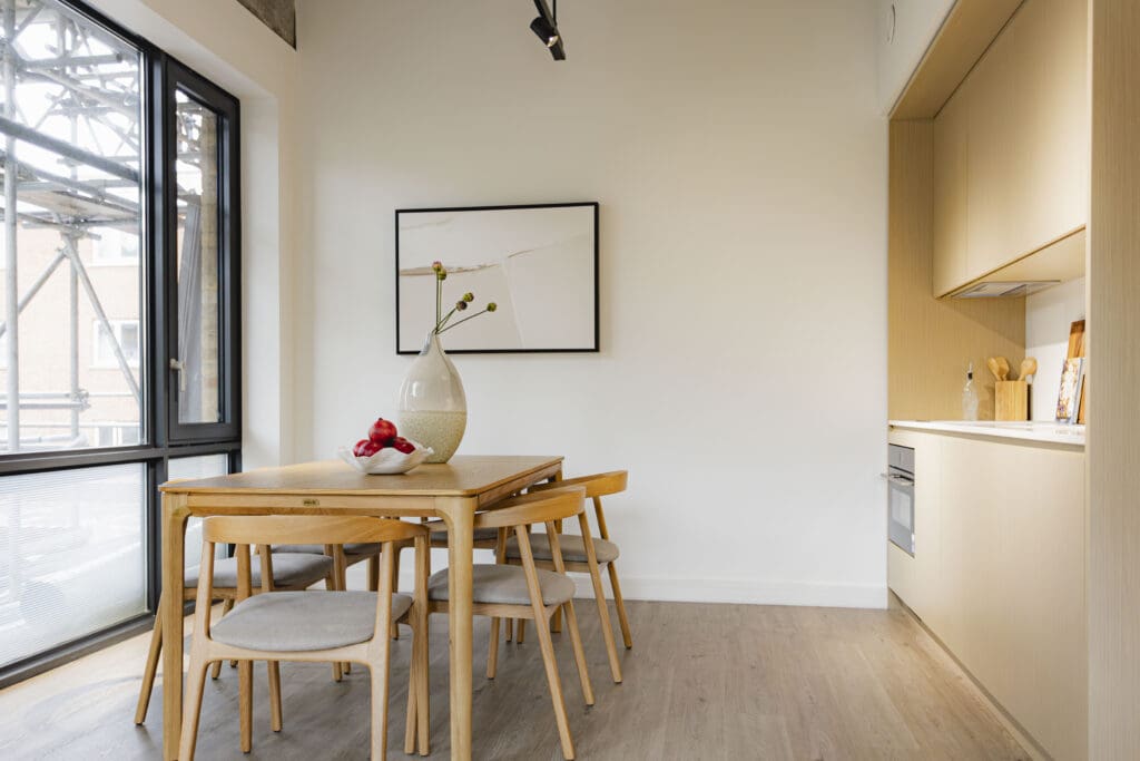 Dining area and kitchen inside a two-bedroom apartment at Gravity Co Hammersmith